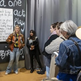 Sara Dahme und die Teilnehmer*innen der Bustour im Gespräch mit der Künstlerin Deepika Arwind vor ihrer Ausstellung im Bauernskriegsmuseum Böblingen.
