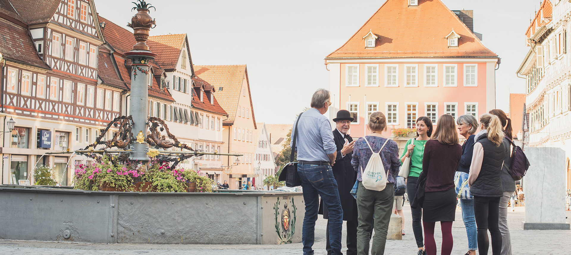 Stadtführung in Schorndorf vor Fachwerkgebäuden und einem Brunnen