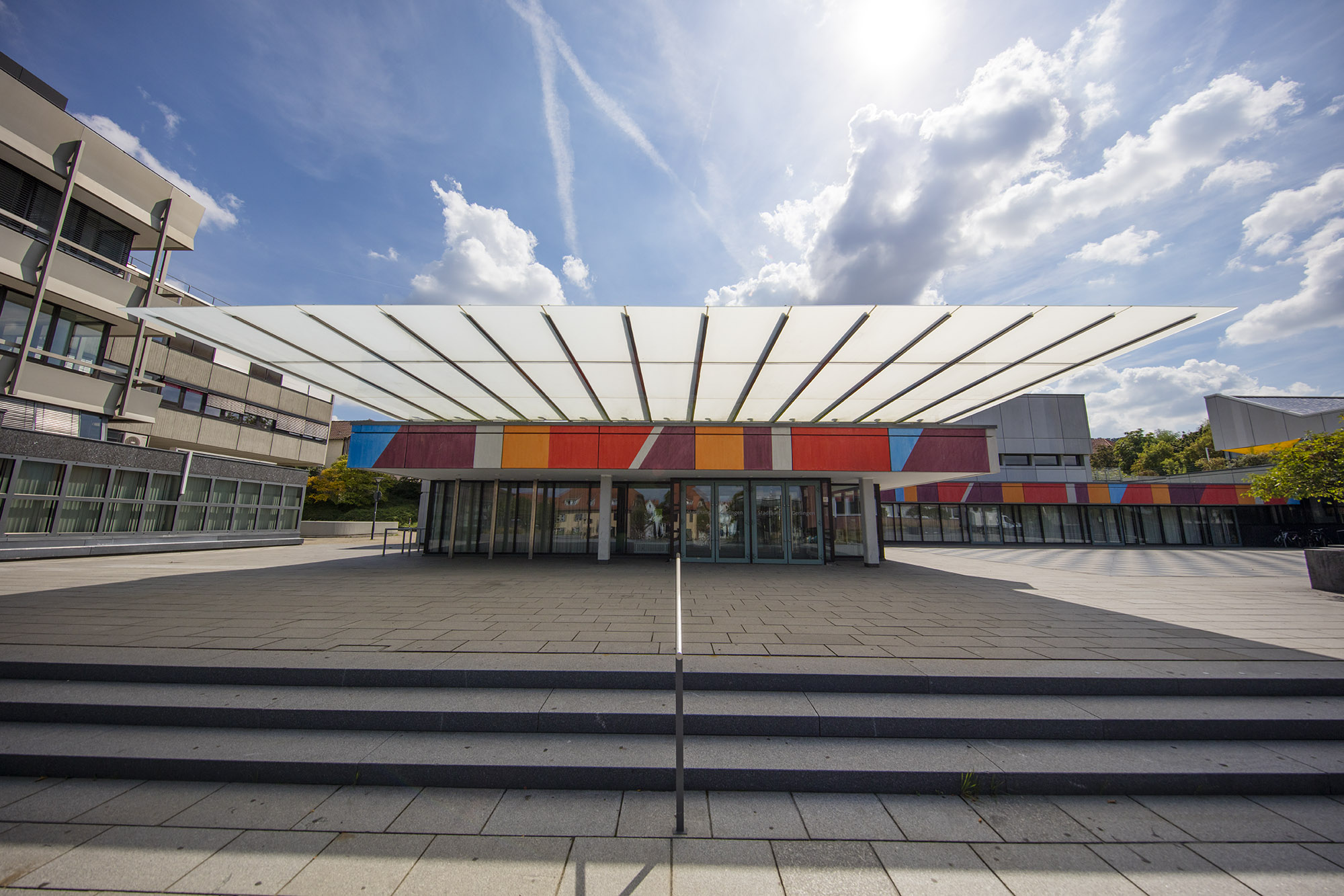 Aussenansicht Stadthalle, Blick auf den bunt gestalteten Eingangsbereich bei strahlendem Sonnenschein