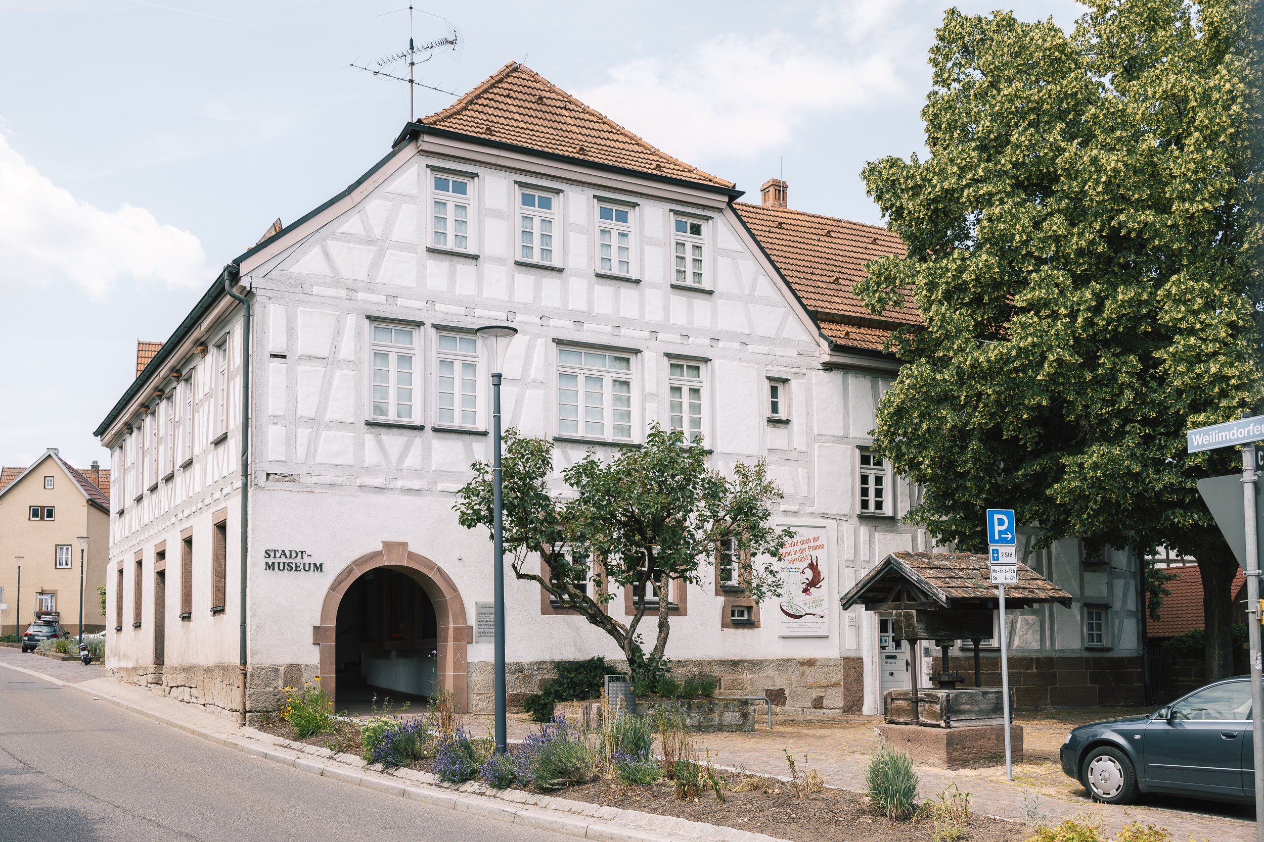 Blick auf das Fachwerkgebäude des Stadtmuseums, Im Vordergrund ein überdachter Brunnenschacht