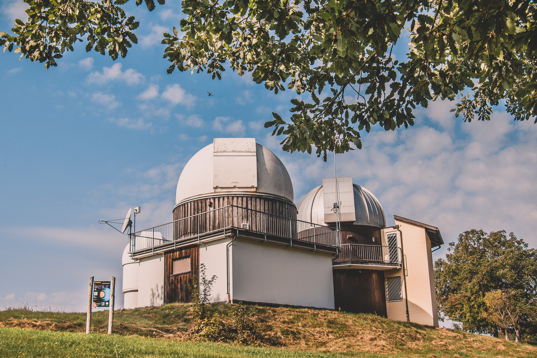 Blick auf die Sternwarte, die auf einem Hügel liegt. Die Sonne scheint.